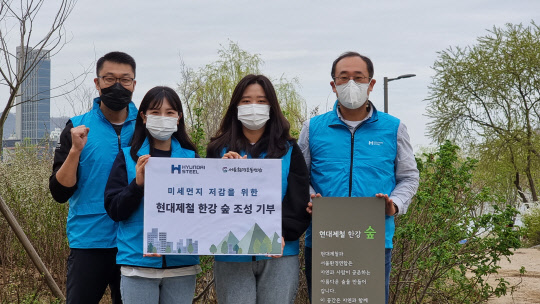 현대제철 임직원들이 한강숲 조성행사에서 기념촬영을 하고 있다. <현대제철 제공>